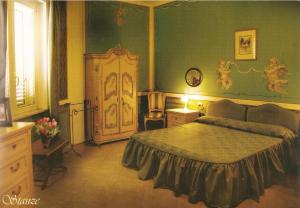 a bedroom with a bed, desk and a painting on the wall at Hotel Rinascimento in Campobasso