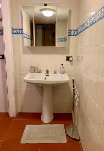 Un baño con un lavabo blanco y un espejo. en Ca' du Ventu - Cozy house with mezzanine & little garage, en Calice Ligure