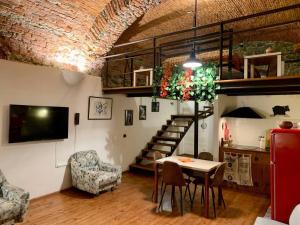 sala de estar con mesa y sillas y escalera en Ca' du Ventu - Cozy house with mezzanine & little garage, en Calice Ligure