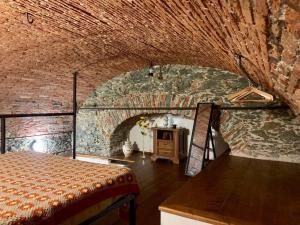 una habitación con una cama y una pared de ladrillo en Ca' du Ventu - Cozy house with mezzanine & little garage, en Calice Ligure