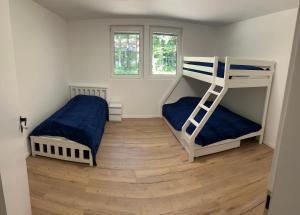 a bedroom with two bunk beds and a wooden floor at Chata Produktivne na Jahodniku in Lošonec +19 photos