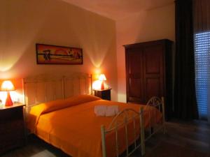 ガリポリにあるB&B Eco Dal Mareのベッドルーム1室(オレンジのシーツとランプ2つ付)