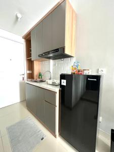 a kitchen with a black refrigerator and a sink at Barsa City by Eleanor in Seturan