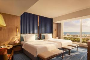 a hotel room with two beds and a large window at Four Seasons Hotel Mumbai in Mumbai +80 photos