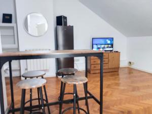 a bar with two stools and a television in a room at habitación BARAJAS in Madrid