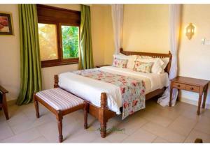 a bedroom with a bed and a window at Villa Mandhari - Diani Beach in Diani Beach