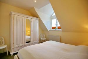 a bedroom with a white cabinet and a bed at Villa Seepferdchen Wohnung 10 in Kühlungsborn