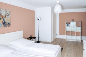 a bedroom with a white bed and a pink wall at Ferienwohnung Schaaf, zentrale Lage, Klimatisiert, Netflix, inklusive Parkplatz in Limburg an der Lahn