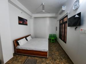 a bedroom with a bed and a clock on the wall at Hotel Mahan Inn in Ayodhya