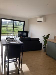 マレスヴィルにあるLes Petites Maisons dans la Prairie - 1のテーブルとソファのあるリビングルーム +9枚の写真