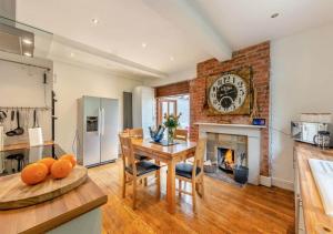 a kitchen and dining room with a table and a fireplace at Luxury Country Escape with Hot Tub perfect for Friends and Families in Shifnal