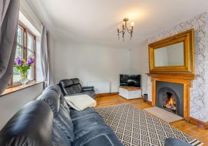 a living room with a leather couch and a fireplace at Luxury Country Escape with Hot Tub perfect for Friends and Families in Shifnal +13 photos