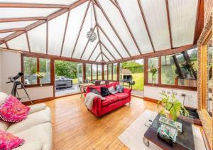 a living room with a red couch and a table at Luxury Country Escape with Hot Tub perfect for Friends and Families in Shifnal