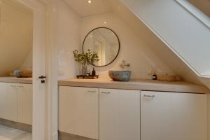a bathroom with a sink and a mirror at Boutique Hoeve de Berg in Uitgeest +16 photos