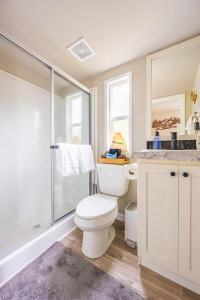 a white bathroom with a toilet and a shower at Rainforest Tiny Home Retreat 19 in Forks