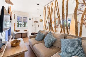 a living room with a couch and trees on the wall at ツ Villa Carrasca l Luxe l Vista al Mar l Piscina Climatizada l Nature in Arenys de Munt