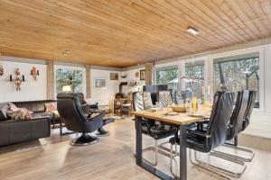 ein Esszimmer mit einem Tisch und Ledersesseln in der Unterkunft Feriehus 1102 in Ulfborg