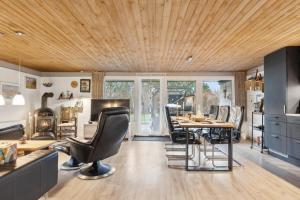 ein Zimmer mit Tisch und Stühlen und eine Küche in der Unterkunft Feriehus 1102 in Ulfborg + 28 Fotos