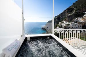 波西塔诺Gianlica Suites Positano的阳台上的热水浴缸,可欣赏海景
