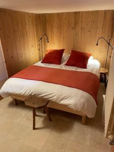 um quarto com uma cama com duas almofadas vermelhas em Joli Appartement familial Centre du village em Megève