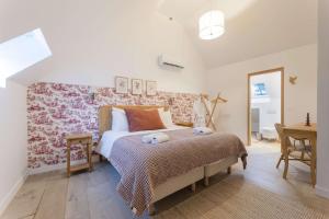 ein Schlafzimmer mit einem großen Bett und einem Schreibtisch in der Unterkunft Maison Morny Your Exquisite Retreat near Deauville in Cricquebœuf