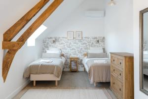 Schlafzimmer im Dachgeschoss mit 2 Betten und einer Kommode in der Unterkunft Maison Morny Your Exquisite Retreat near Deauville in Cricquebœuf
