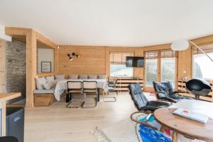 uma sala de estar com um sofá e uma mesa em Joli Appartement familial Centre du village em Megève