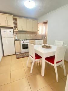 a kitchen with a white table and white appliances at Maridina cottage Corfu Village in Kastellánoi +18 photos