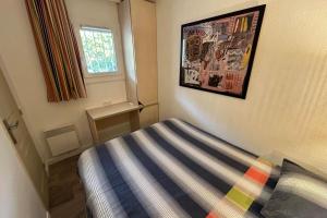 ein Schlafzimmer mit einem Bett und einem Bild an der Wand in der Unterkunft L'Anse de Pramousquier T2 Vue Mer ! Bord de plage in Le Lavandou + 10 Fotos