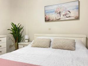 a bedroom with a white bed with a bike painting on the wall at Maridina cottage Corfu Village in Kastellánoi