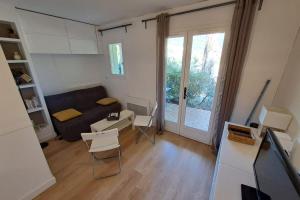 ein Wohnzimmer mit einer Couch und einem Tisch und Stühlen in der Unterkunft F2 at "Domaine de la Pinède" Heated Swimming Pool in Le Lavandou