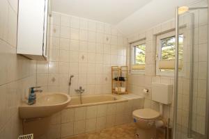a bathroom with a sink and a toilet and a tub at Dat Bienenhuus in Putbus +27 photos