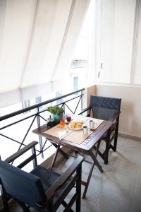 a table with a plate of food on a balcony at Ιasonas Apartment in Nafplio +21 photos