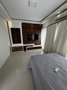 a bedroom with a bed and a kitchen in it at Apto 2 in Florianópolis