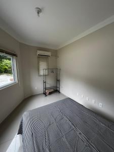 a bedroom with a bed in a room with a window at Apto 2 in Florianópolis