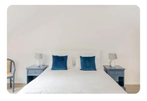 a bedroom with a white bed with blue pillows at The Boat Shed, Westport in Westport