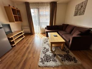 Una sala de estar con un sofá y una mesa de café. en Top Lodge twobedroom apartment, en Bansko 14 fotos más