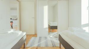 a white room with two beds and a mirror at 1 BR Apartment - Tórshavn - Parking in Tórshavn +11 photos