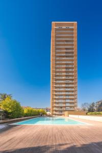 a tall building with a swimming pool in front of a building at Giax Tower-Pool,Spa&Gym-Niguarda Hospital-10min to Duomo in Milan