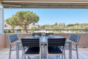 stół i krzesła na balkonie z widokiem w obiekcie T2 in Lavandou - Residence with Swimming Pool w mieście Le Lavandou