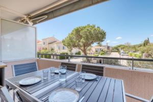 stół na balkonie z widokiem na ulicę w obiekcie T2 in Lavandou - Residence with Swimming Pool w mieście Le Lavandou +12 zdjęć