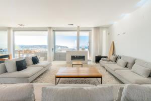 a large living room with couches and a table at Villa Surf Vista - Praia da Areia Branca in Lourinhã