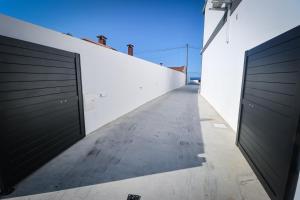 a hallway with two garage doors on a white wall at Apartamento Amanhecer in Rabo de Peixe
