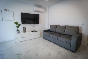 a living room with a couch and a flat screen tv at Apartamento Amanhecer in Rabo de Peixe