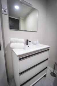 a white bathroom with a sink and a mirror at Apartamento Amanhecer in Rabo de Peixe