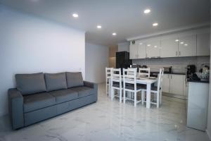 a living room with a couch and a table and a kitchen at Apartamento Amanhecer in Rabo de Peixe