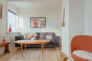 a living room with a couch and a table at Charming House - Stunning views - Parking in Torkilsheyggjur