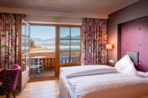 ein Schlafzimmer mit Bett und Balkon mit Aussicht in der Unterkunft Hotel Sommer-Haus am See in Füssen