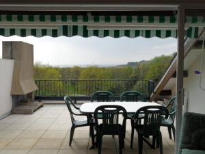 a patio with a table and chairs on a balcony at REF 014 - T2 mezzanine pour quatre personnes Terrasses de Kerjouanno ARZON in Arzon +11 photos