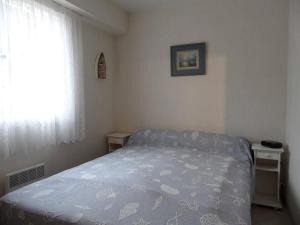 a small bedroom with a bed and a window at REF 014 - T2 mezzanine pour quatre personnes Terrasses de Kerjouanno ARZON in Arzon